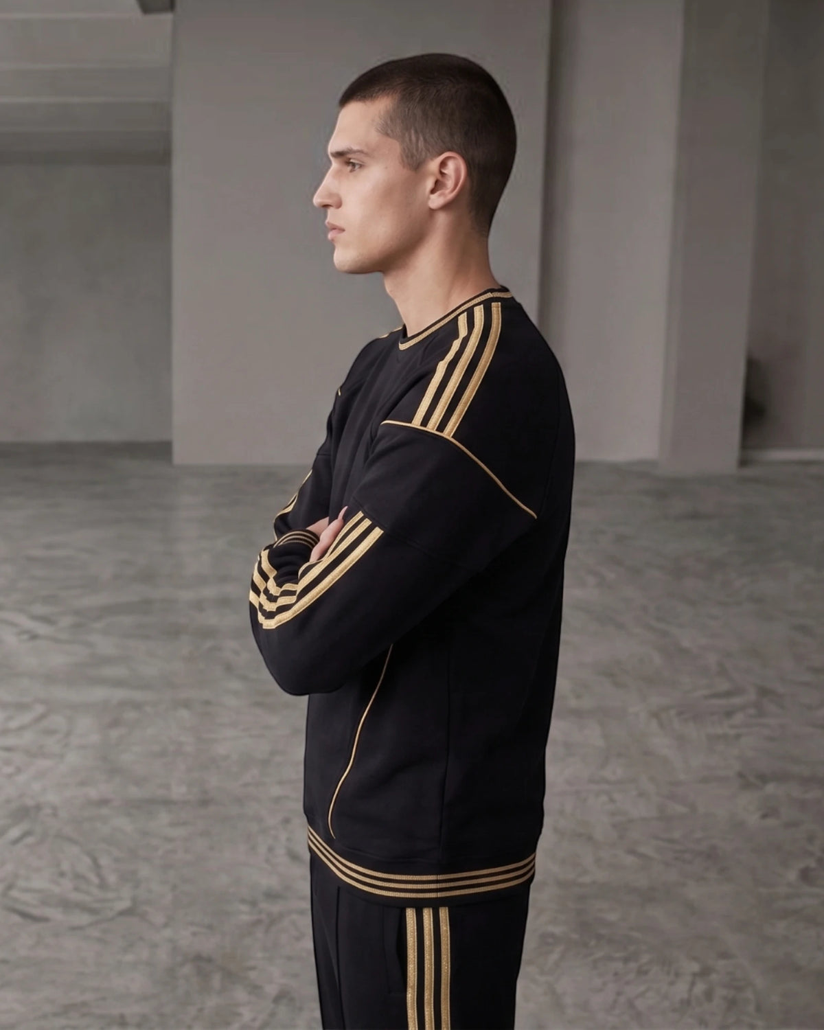 Black and gold stripe embroidered crewneck sweatshirt, side view showing gold sleeve stripes