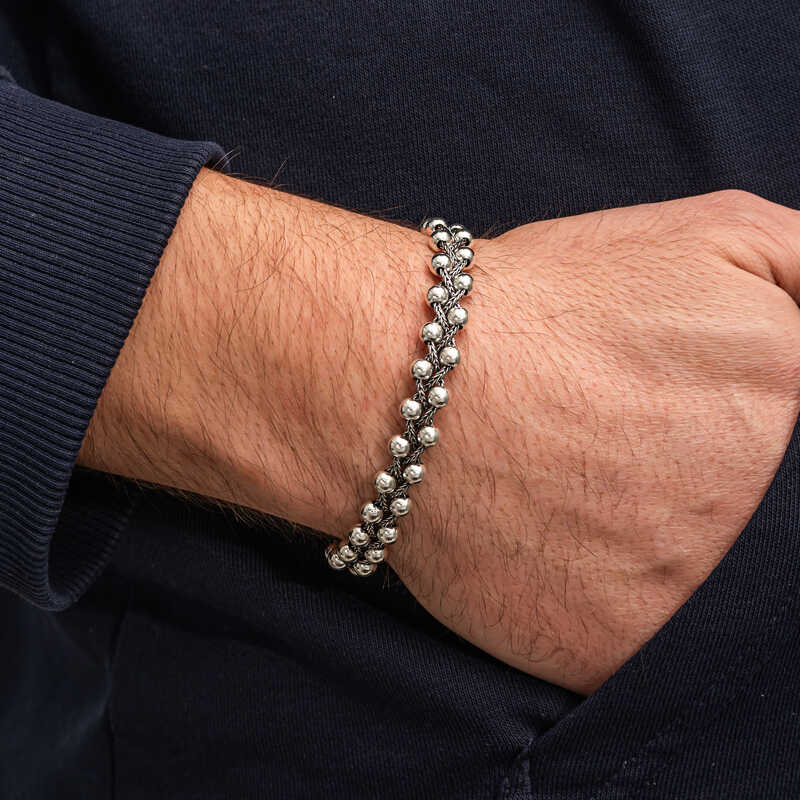 Men's oxidized sterling silver double row bead bracelet worn on wrist with navy knit sweater