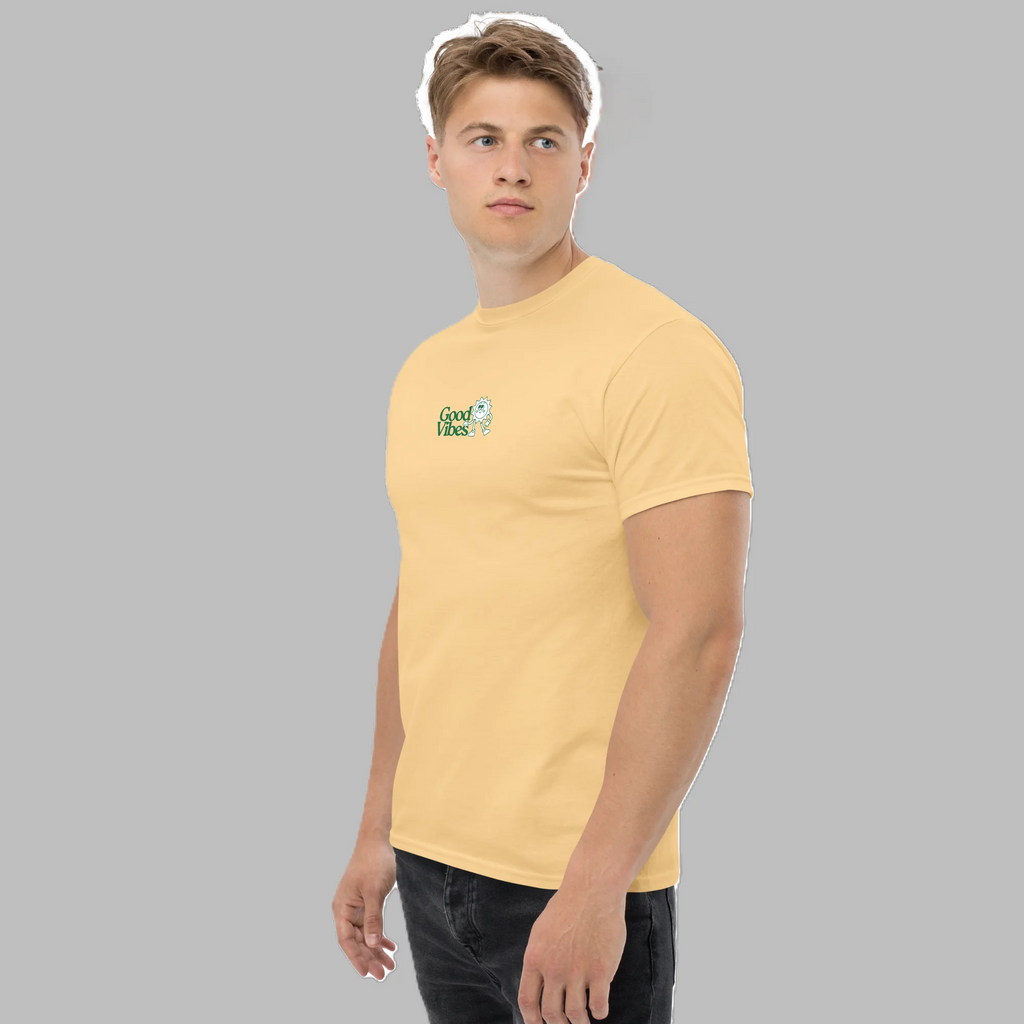 Front three-quarter view of male model wearing pastel yellow graphic t-shirt with small Good Vibes logo