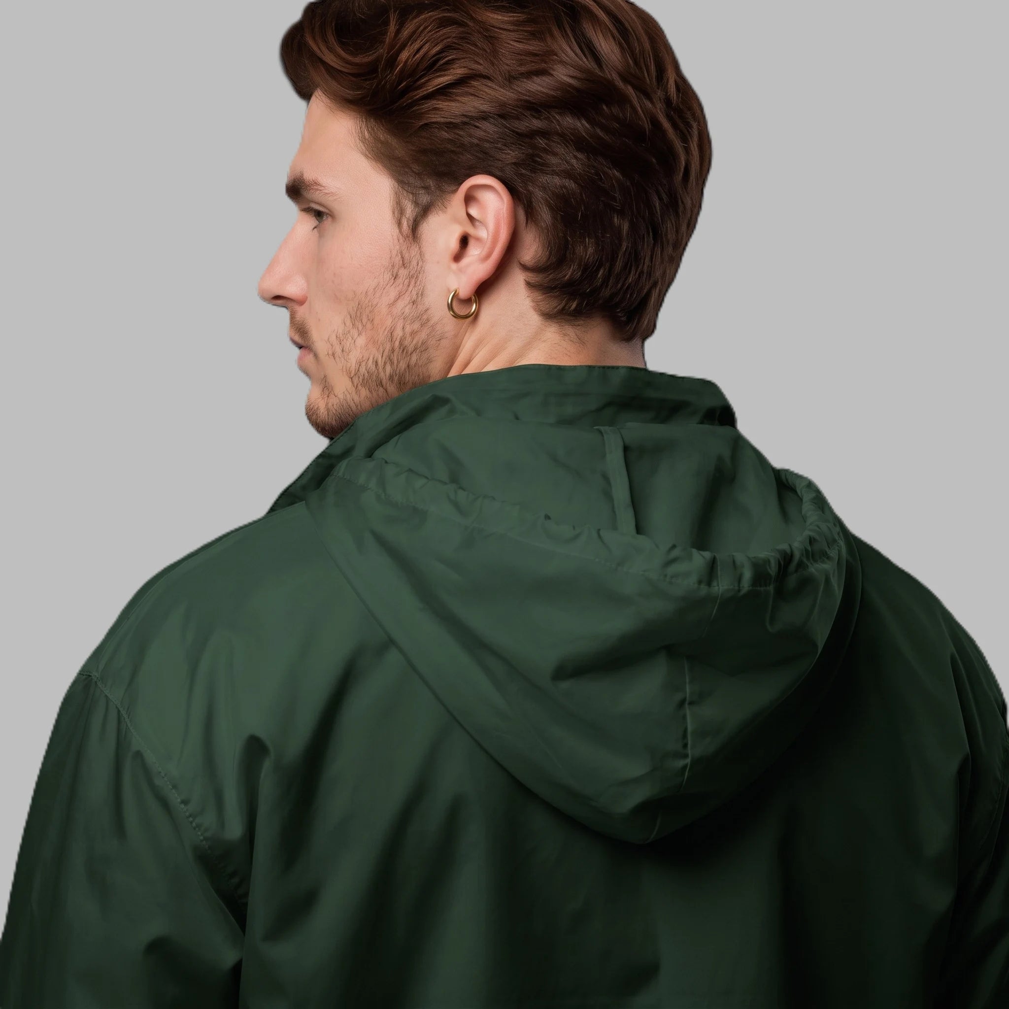 Back-angle close-up of male model wearing forest green hooded windbreaker jacket showcasing hood detail