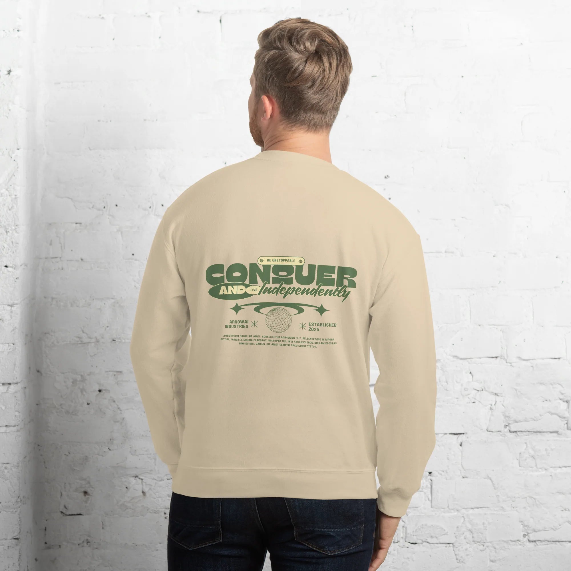 Male model from back wearing sand beige crewneck sweatshirt with green Conquer and Live Independently graphic print