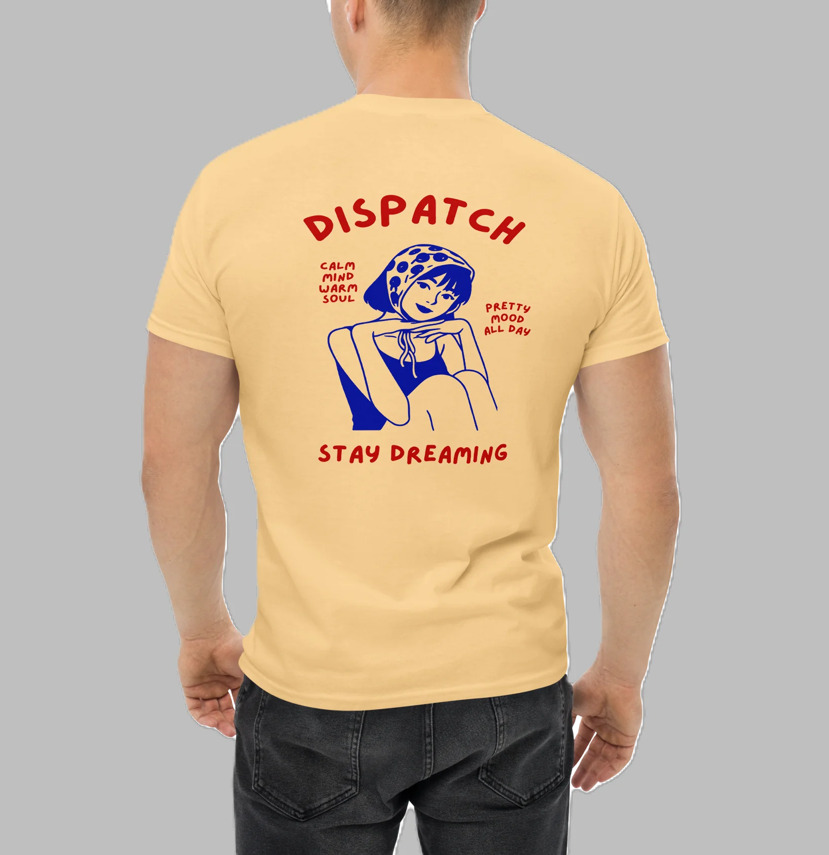 Male model from back wearing pastel yellow t-shirt with retro Dispatch Stay Dreaming girl illustration graphic print