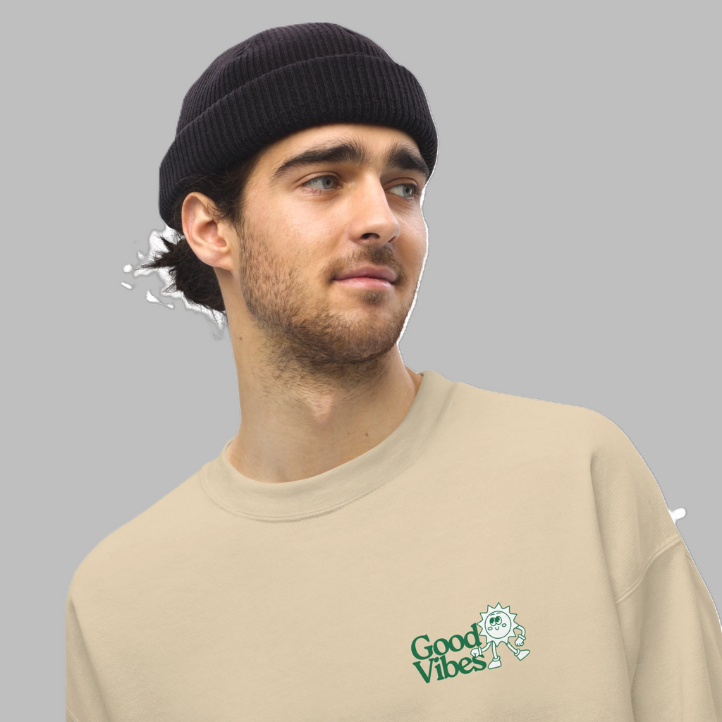Close-up shot of male model wearing sand beige crewneck sweatshirt with green Good Vibes chest print