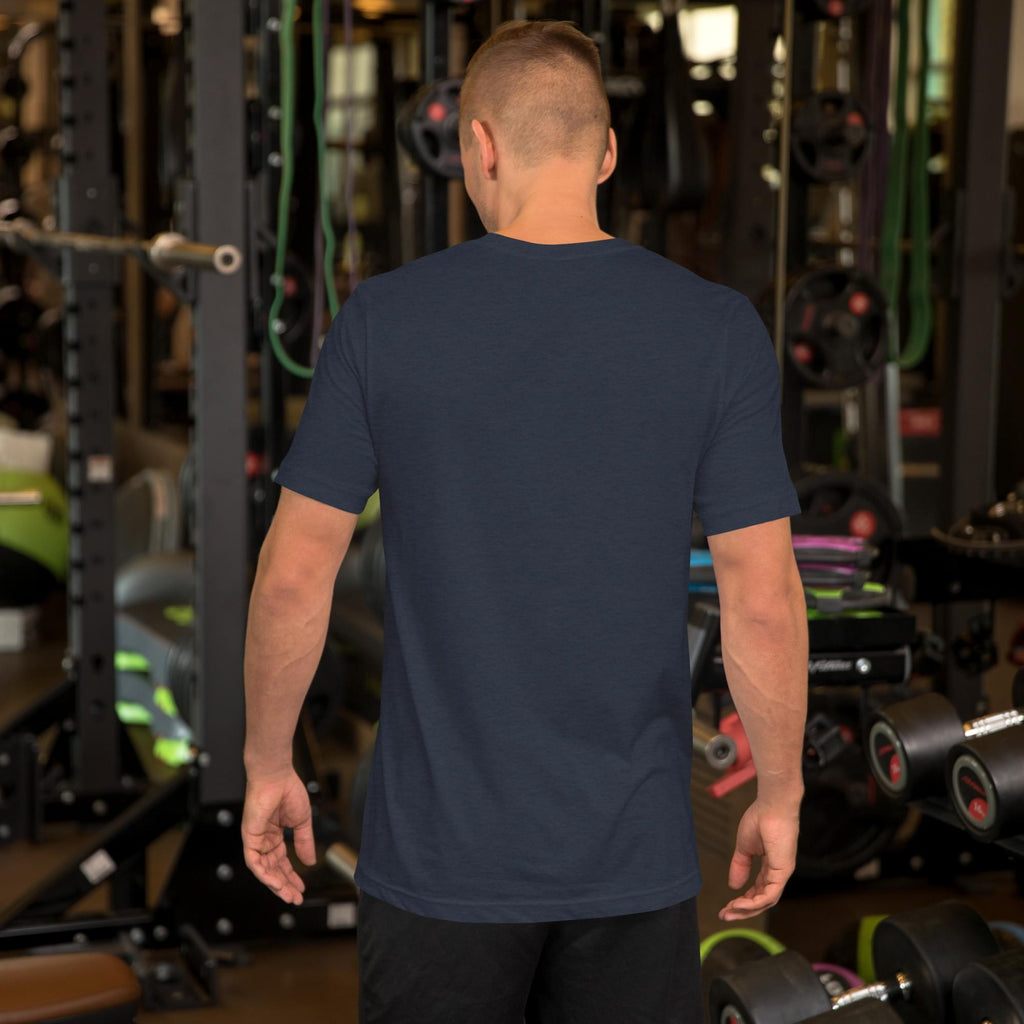 A man in a navy blue Summerween t-shirt, seen from behind, standing in a gym with fitness equipment.