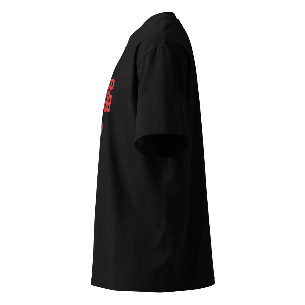Side profile view of the oversized black organic cotton t-shirt, showcasing the relaxed drop-shoulder fit and a partial view of the red front graphic.