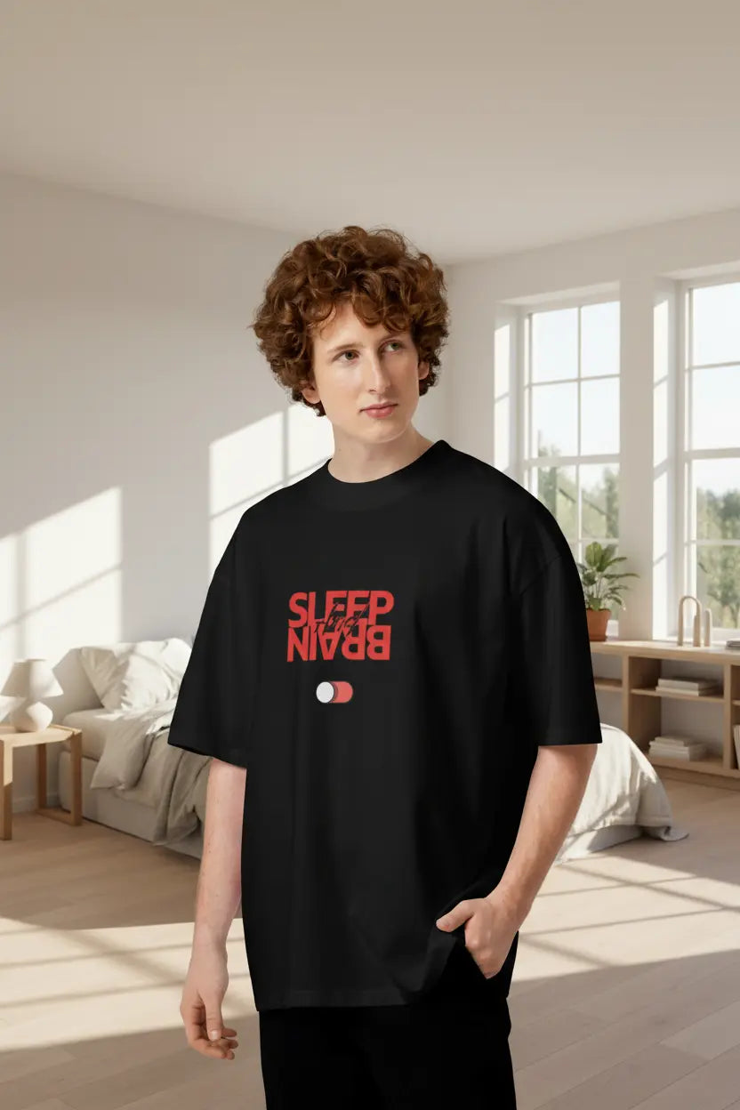 Man wearing an oversized black organic cotton t-shirt with a red Sleep and Brain toggle switch graphic on the front.