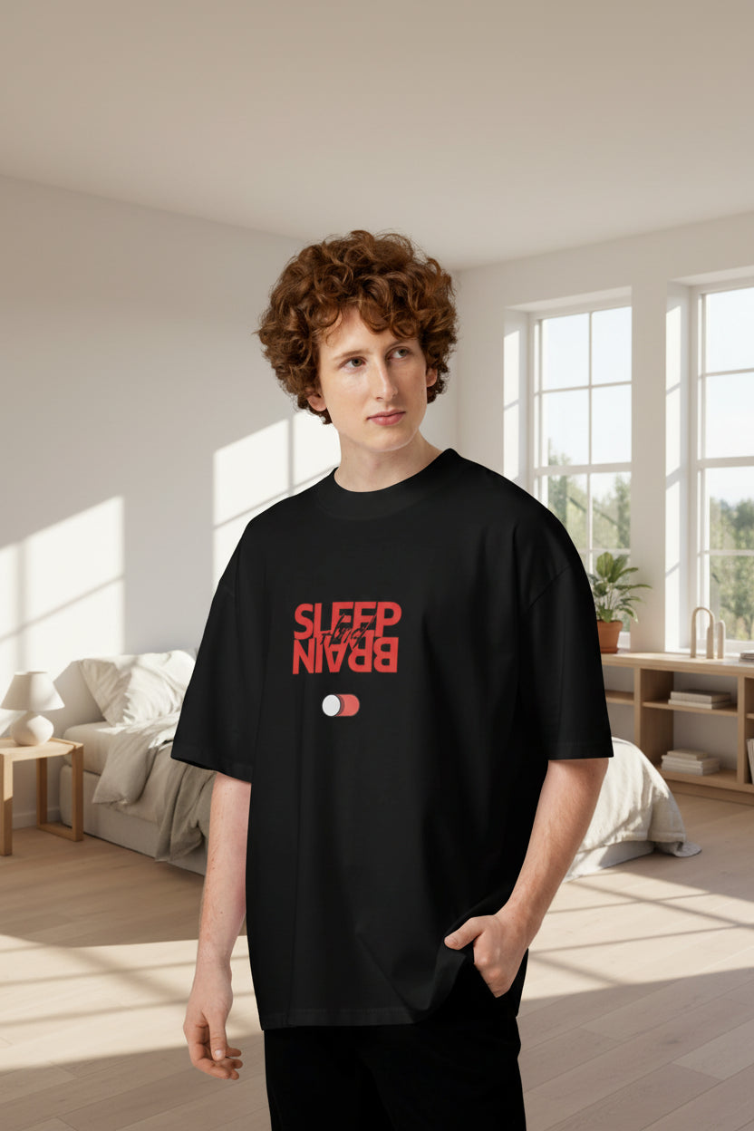 Man wearing an oversized black organic cotton t-shirt with a red Sleep and Brain toggle switch graphic on the front.