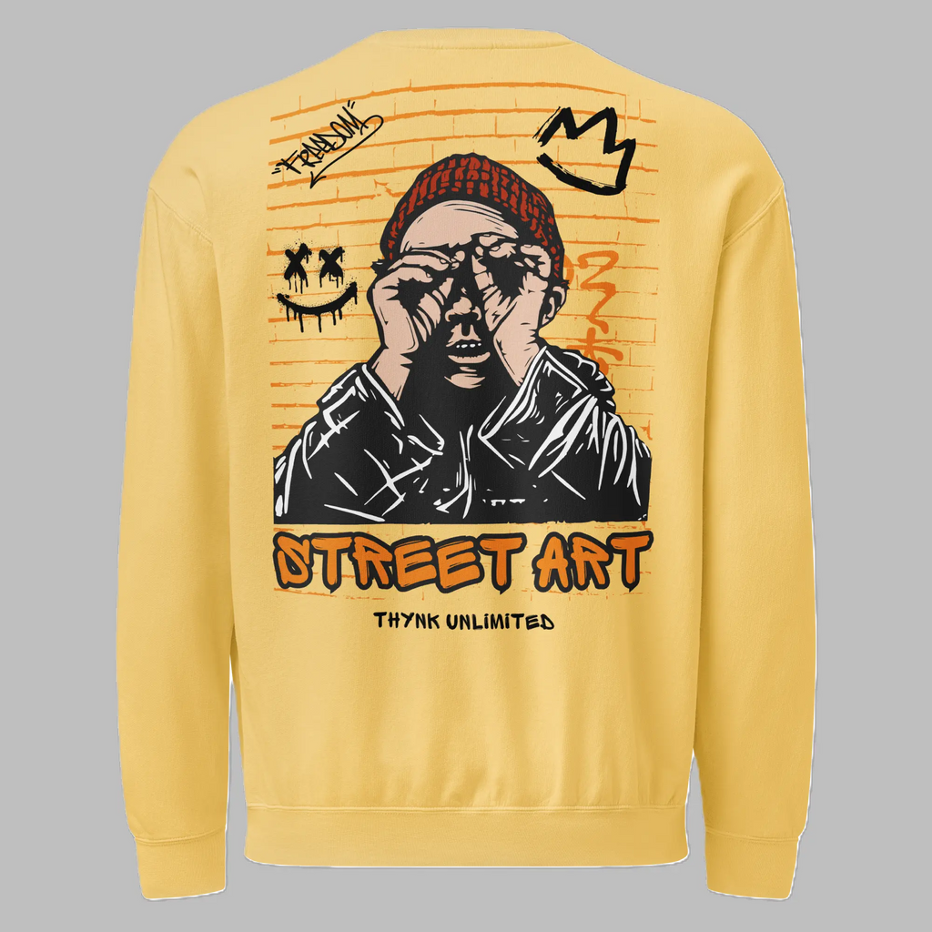 Back view of a yellow crewneck sweatshirt featuring a large brick-pattern street art graphic of a person wearing a red beanie, binoculars gesture, graffiti crown, and smiley face, with 'STREET ART' and 'THYNK UNLIMITED' printed below.