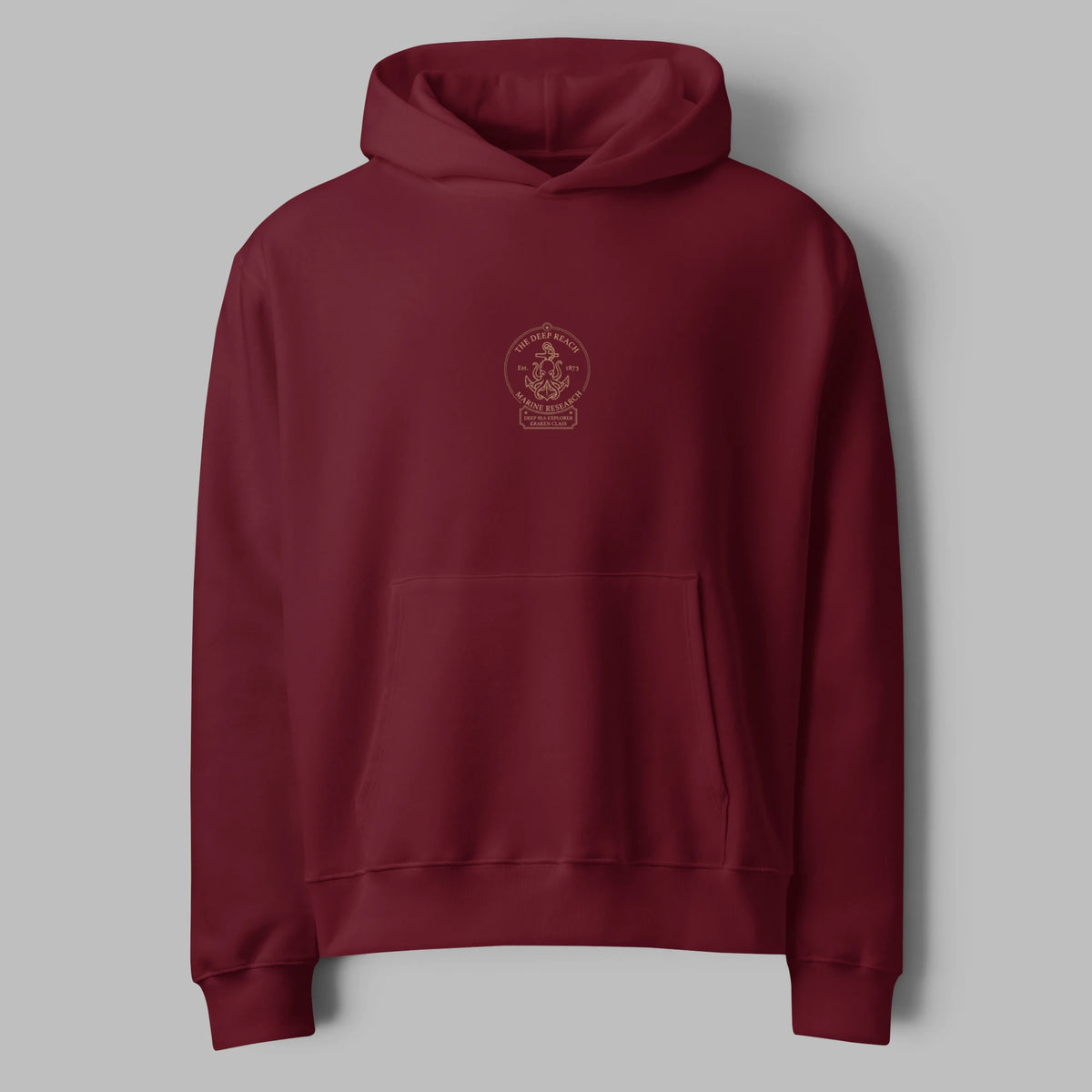 Flat lay front view of an oversized burgundy maroon hoodie featuring a minimal center chest print and pouch pocket