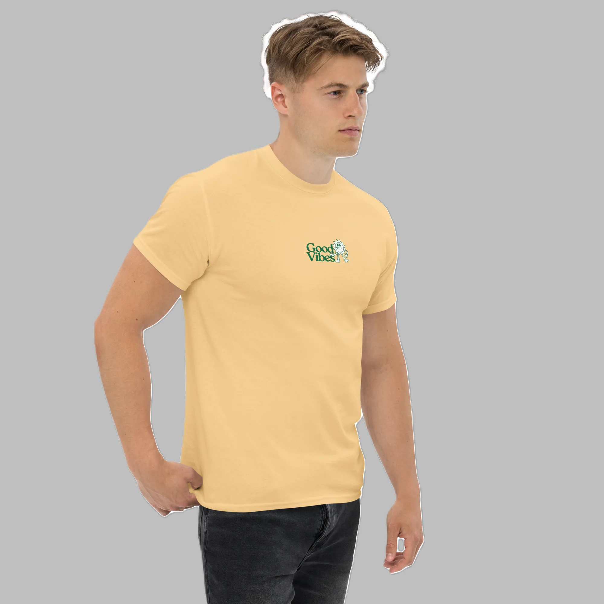 Side-angle view of male model wearing pastel yellow t-shirt with small green Good Vibes chest print