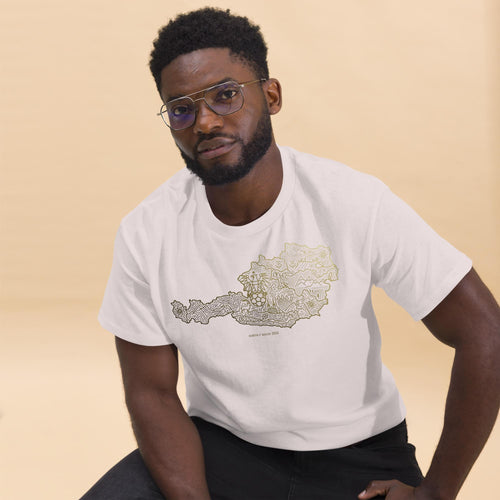 Close-up look of the white unisex cotton t-shirt with gold Austria soccer map design, worn by a male model with glasses for a modern streetwear vibe.